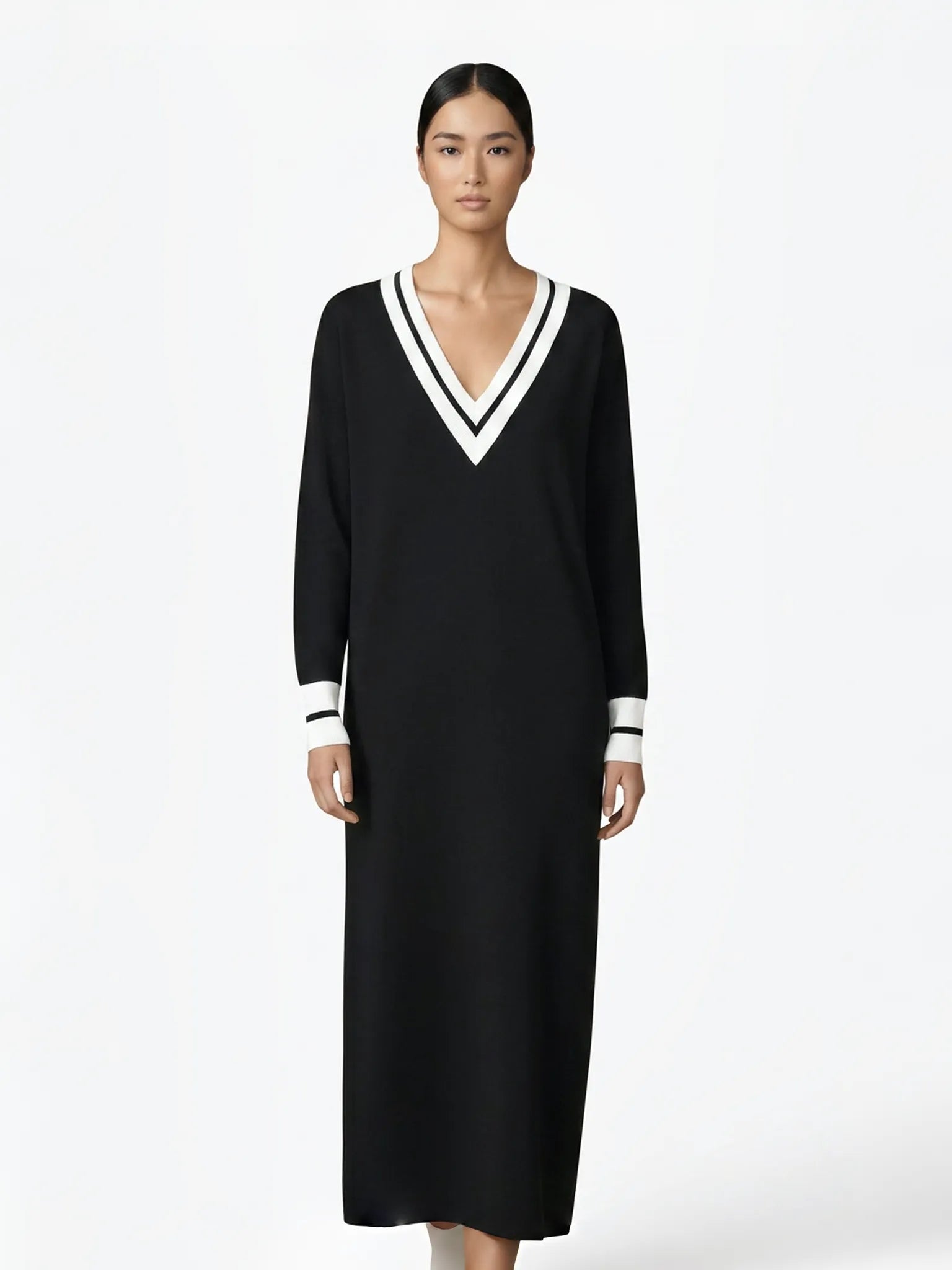 Woman wearing a black dress with white trim on a white background