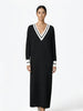 Woman wearing a black dress with white trim on a white background