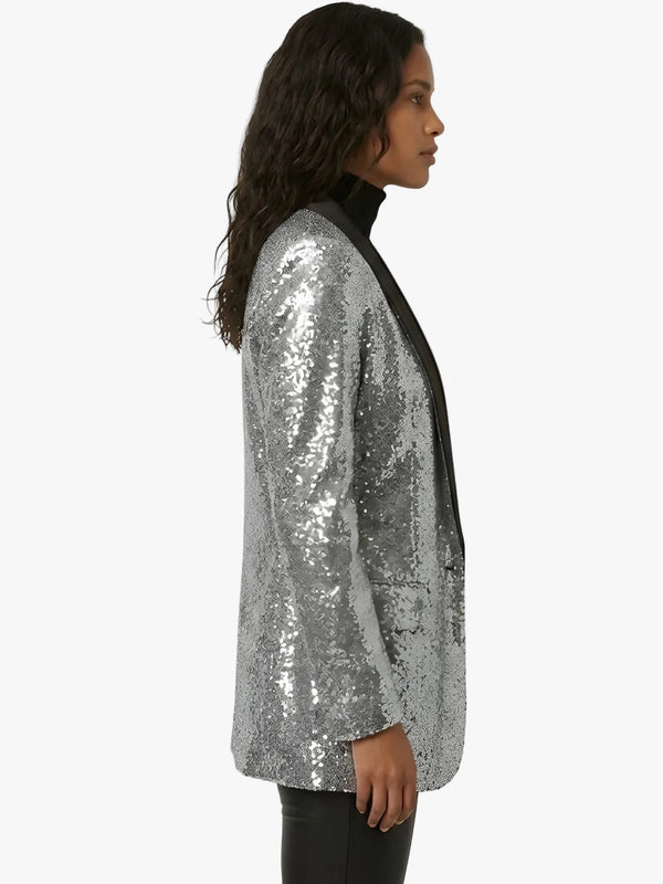 Person wearing a silver sequin jacket on a white background
