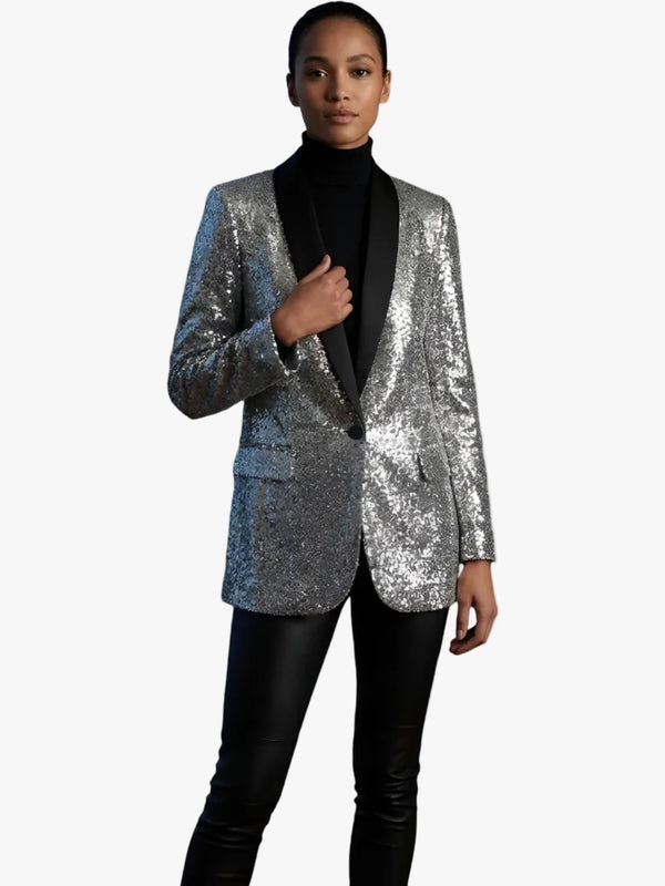 Person wearing a silver sequin blazer over a black outfit on a white background