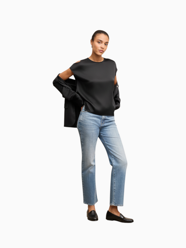 Model wearing a Queen Anna House of Fashion black silk draped top with light wash jeans and black loafers
