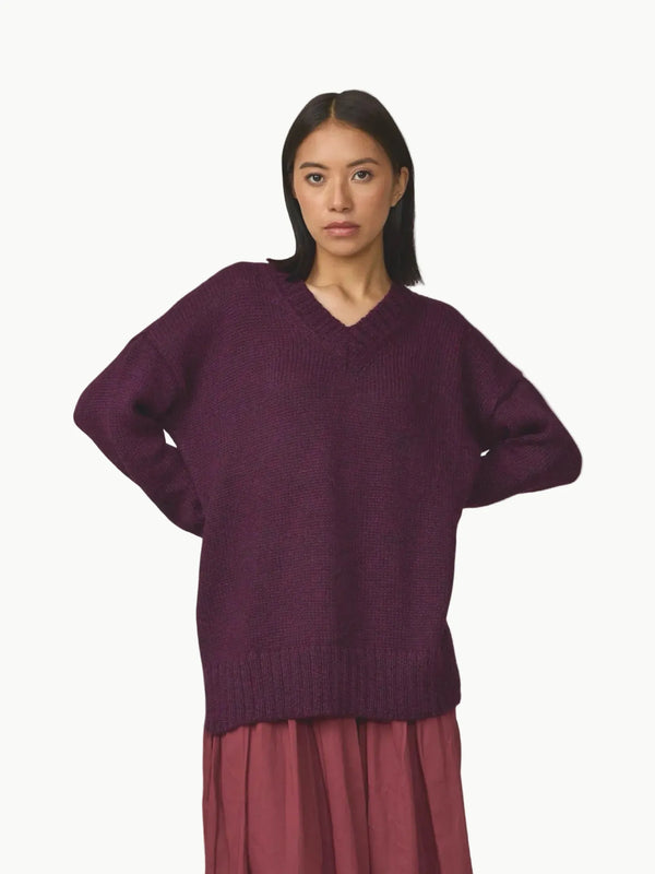 Woman wearing a purple sweater on a white background