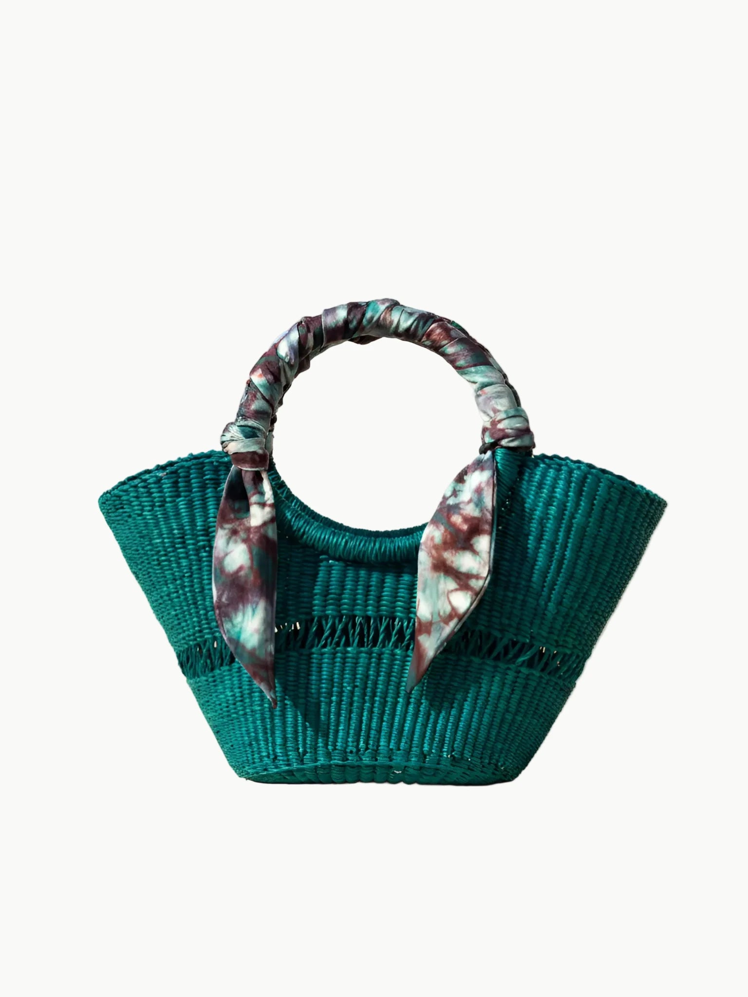 Teal woven handbag with floral handle on a beige background