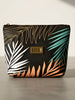 Makeup bag with tropical leaf pattern and 'BOSSY' brand on a neutral background