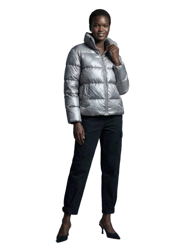 Person wearing a silver puffer jacket in a gray room