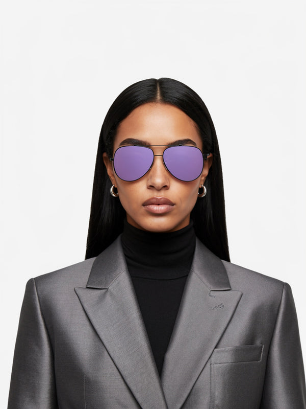 Woman wearing a gray suit and purple sunglasses on a white background