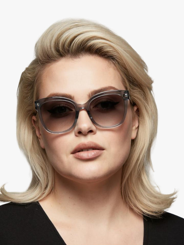 Woman wearing sunglasses with a neutral background
