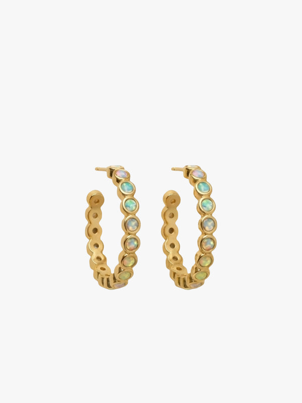 Gold hoop earrings with green gemstones on a white background