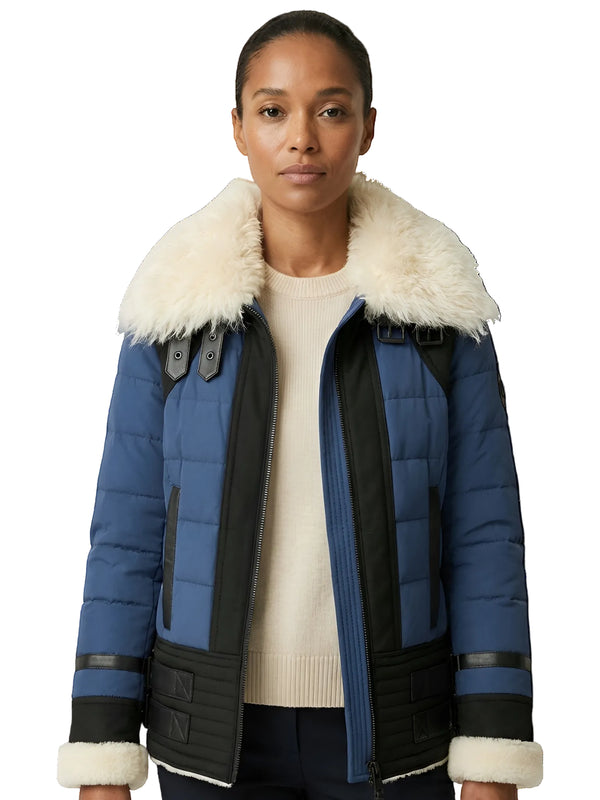 Woman wearing a blue and black jacket with white fur trim on a white background
