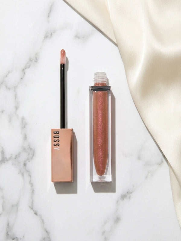 Lip gloss with applicator on a marble surface