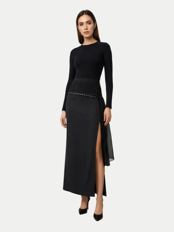 Woman wearing a black dress with a slit on a white background