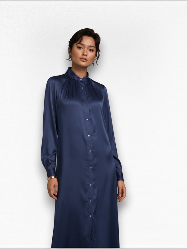 The Camilla Dress by Neu Nomads is constructed from 100% Satin TENCEL™ Modal, with a refined polo collar, long sleeves, and a button-up shirt dress silhouette featuring a 2-inch belt. Biodegradable mother-of-pearl shell buttons and French seam finishing complete the garment.
