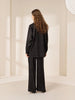 Queen Anna House of Fashion model wearing a black satin long-sleeve shirt and wide-leg pants with a subtle pattern.