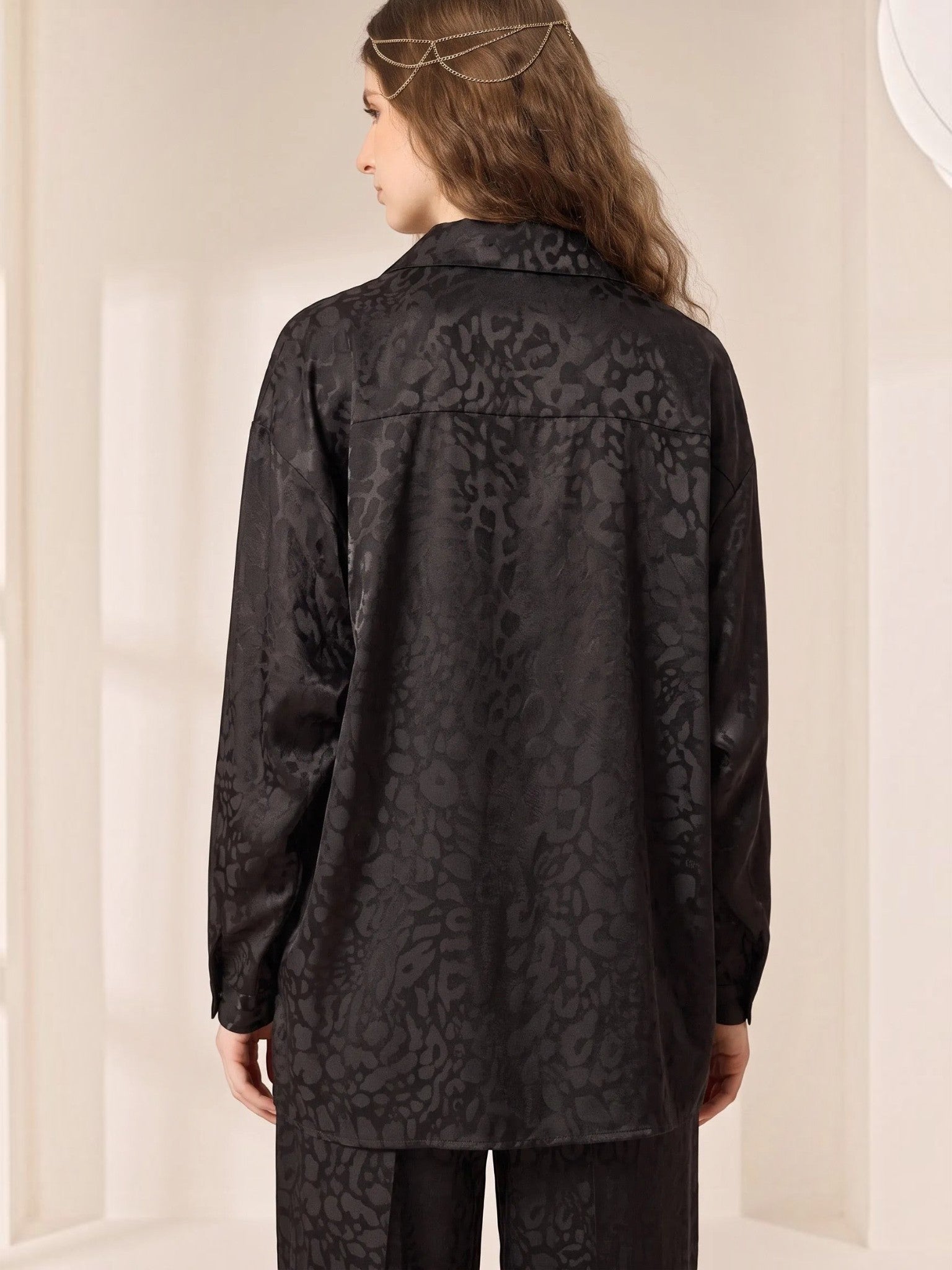 Queen Anna House of Fashion black satin shirt with subtle animal print pattern worn by a model from the back view