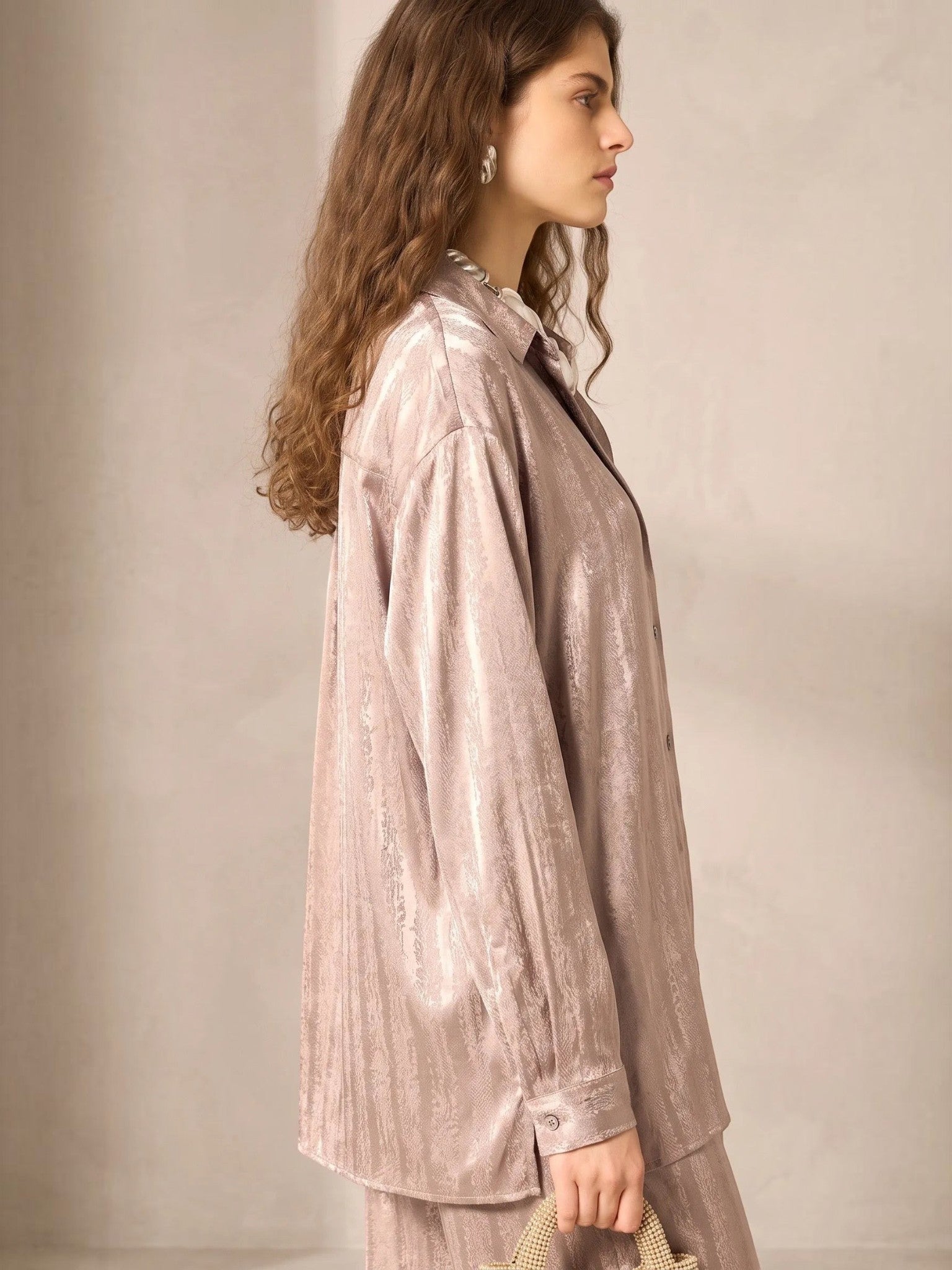 Model wearing a beige satin button-down shirt from Queen Anna House of Fashion with a fluid, relaxed drape