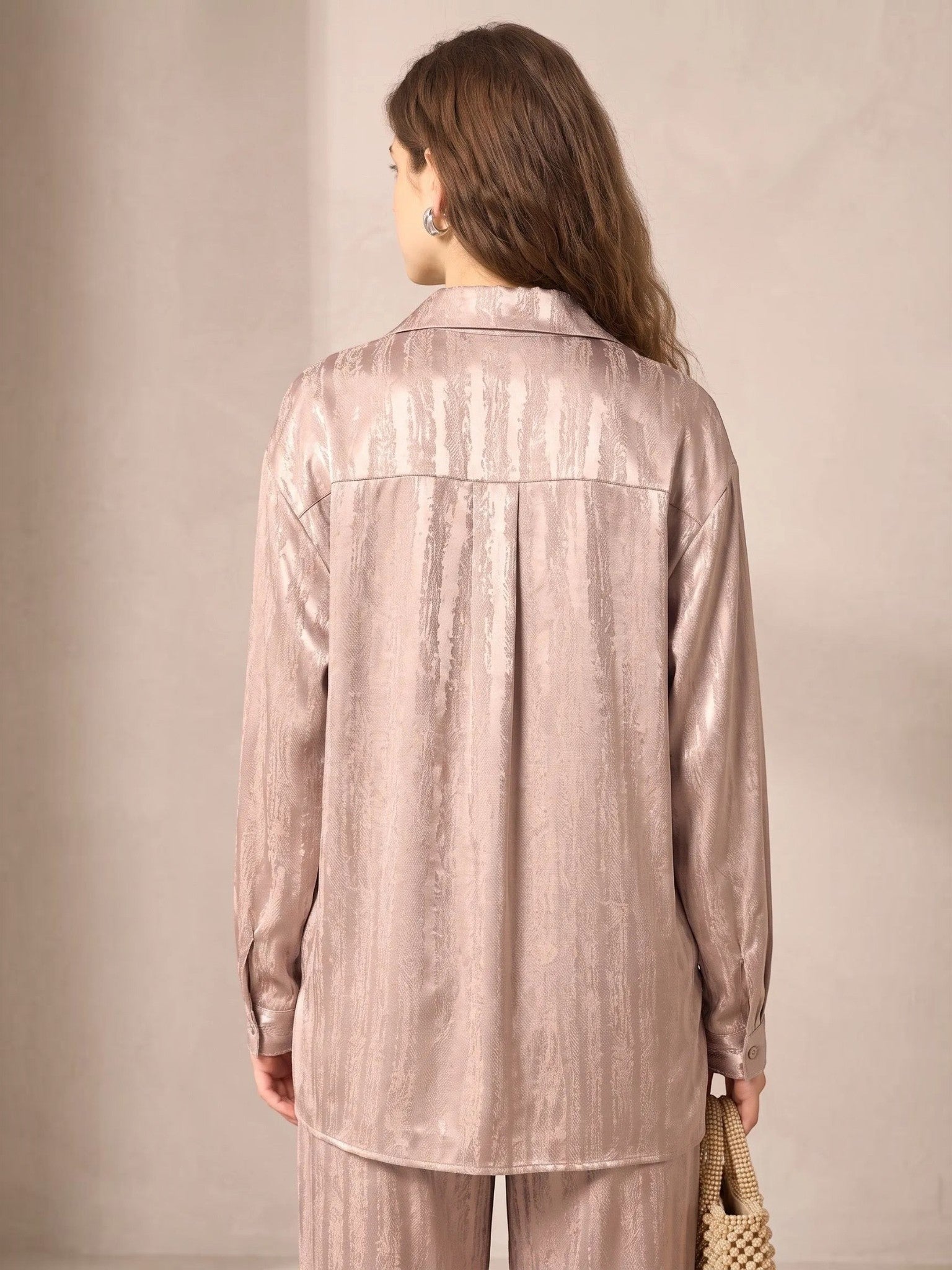 Back view of a model wearing a Queen Anna House of Fashion beige satin shirt with a subtle textured pattern.