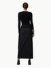 Black dress with gold accents worn by a model on a white background