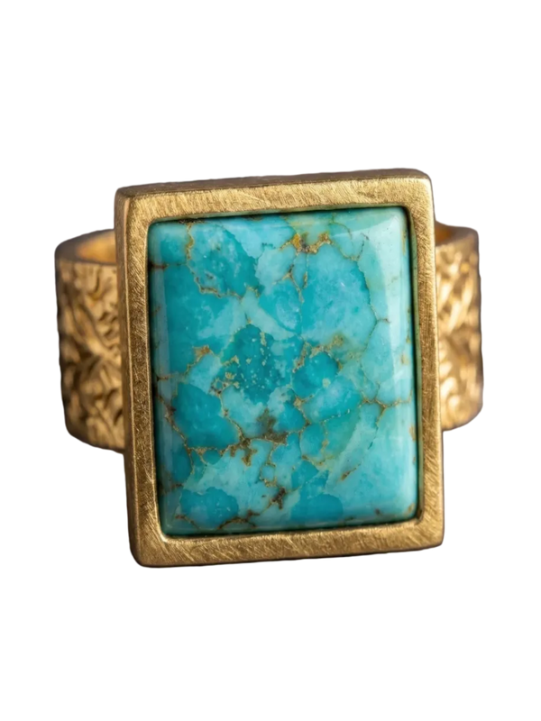 Gold ring with a turquoise stone on a dark textured background