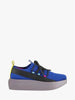 Blue and black sneaker with a yellow tag on a gray background