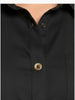 A full-length shot of a plus-size model wearing a black, knee-length stretch poplin shirtdress. The dress features a classic collar, light contrast buttons down the front, a left chest pocket, and side seam pockets where her hands are resting. She is styled with black strappy block heels.