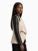 Blanc Noir Drape Front Jacket in taupe with black contrast sleeves, side profile on model