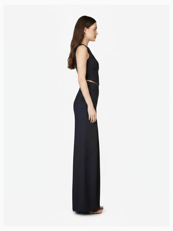 Side profile of model wearing Article X Black Wide Leg Pant and sleeveless crop top, showing structured design