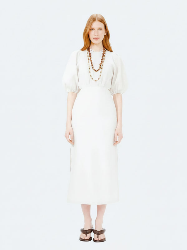Woman wearing a white dress with long sleeves on a white background