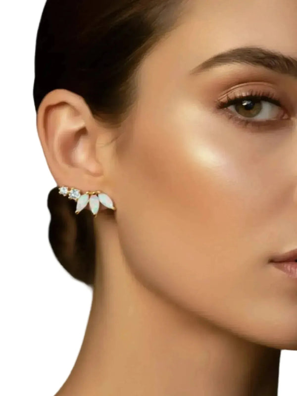Close-up of a woman wearing a pair of earrings with a neutral background