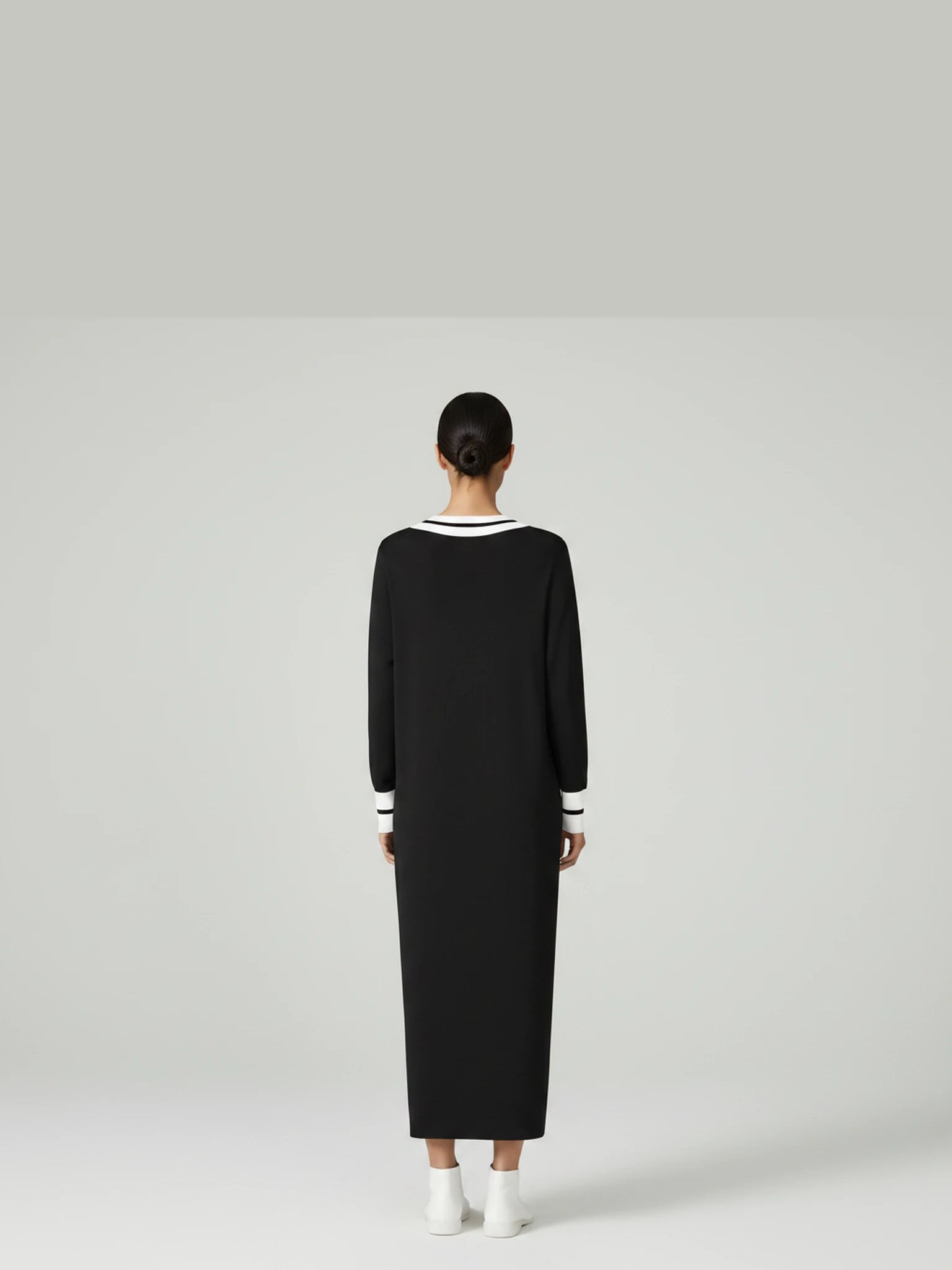 Detail back-facing view of the Lanhtropy Preppy Knitted Dress in black knit on a model, showcasing the clean vertical back line and knit texture.