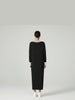 Detail back-facing view of the Lanhtropy Preppy Knitted Dress in black knit on a model, showcasing the clean vertical back line and knit texture.