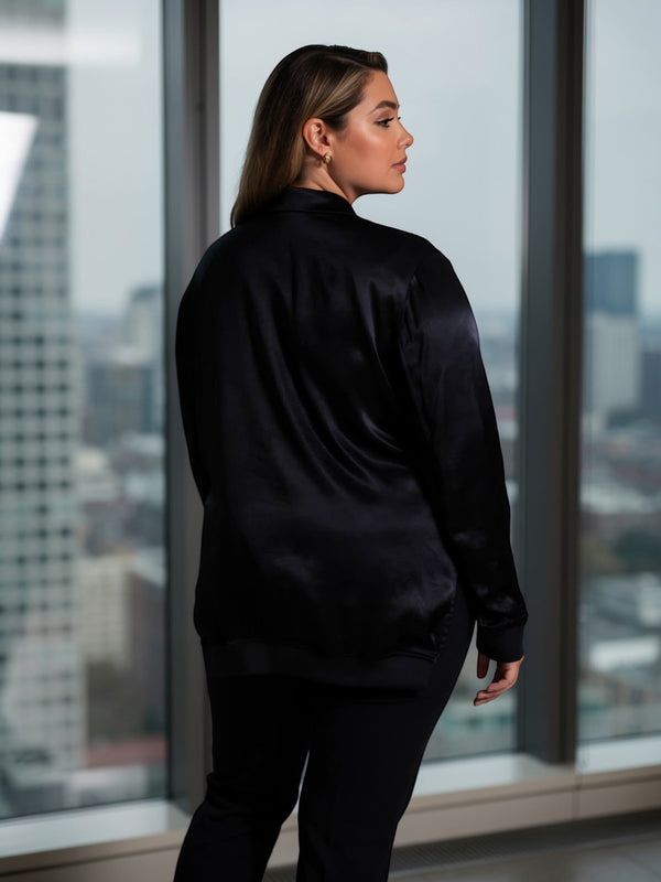Queen Anna House of Fashion model wearing a black Universal Standard satin bomber jacket with a relaxed fit