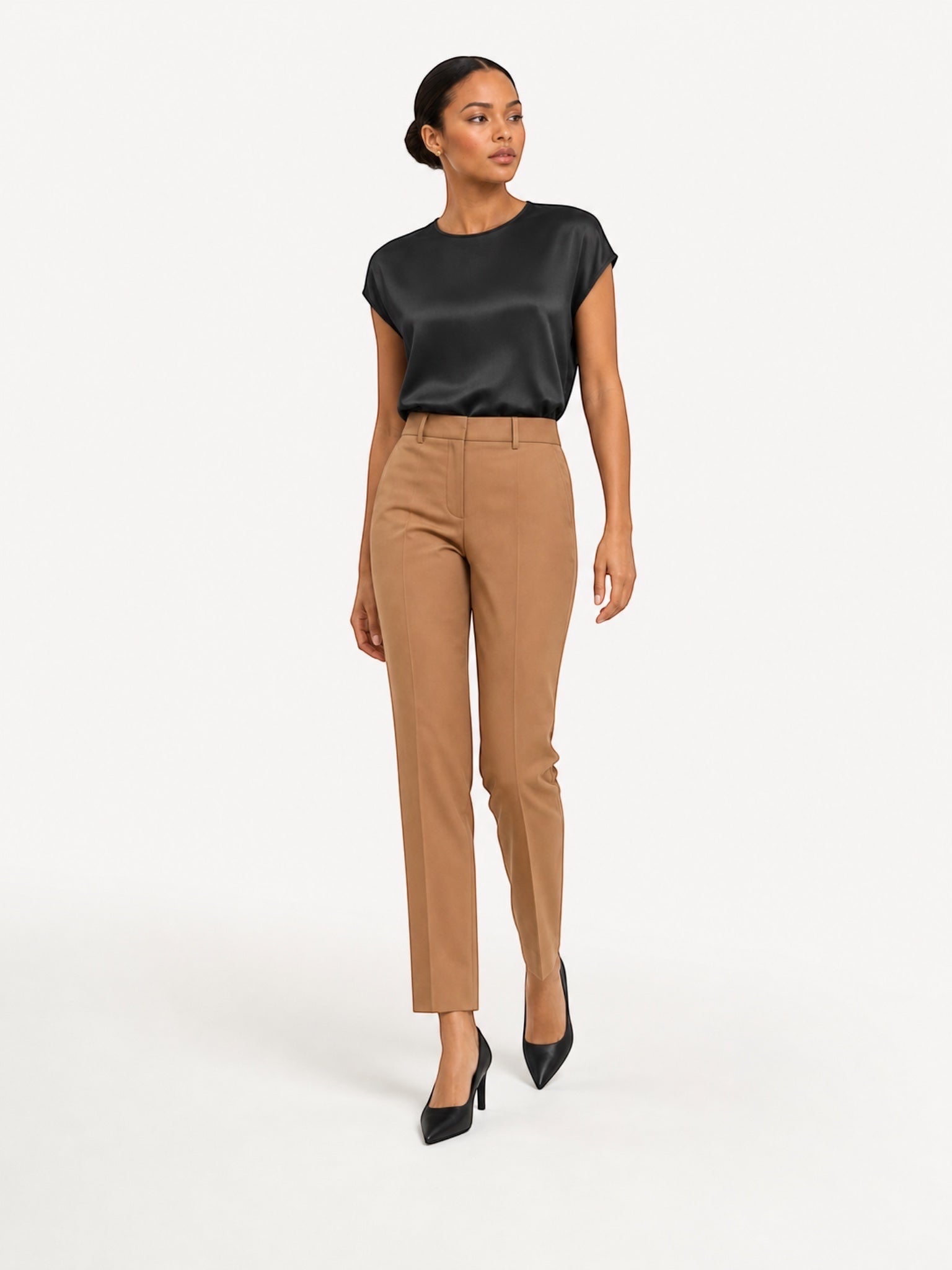 Model wearing a Queen Anna House of Fashion black washable silk charmeuse top tucked into tan tailored trousers.