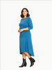 Model wearing a Queen Anna House of Fashion blue jersey cinched dress with three-quarter sleeves and black boots.
