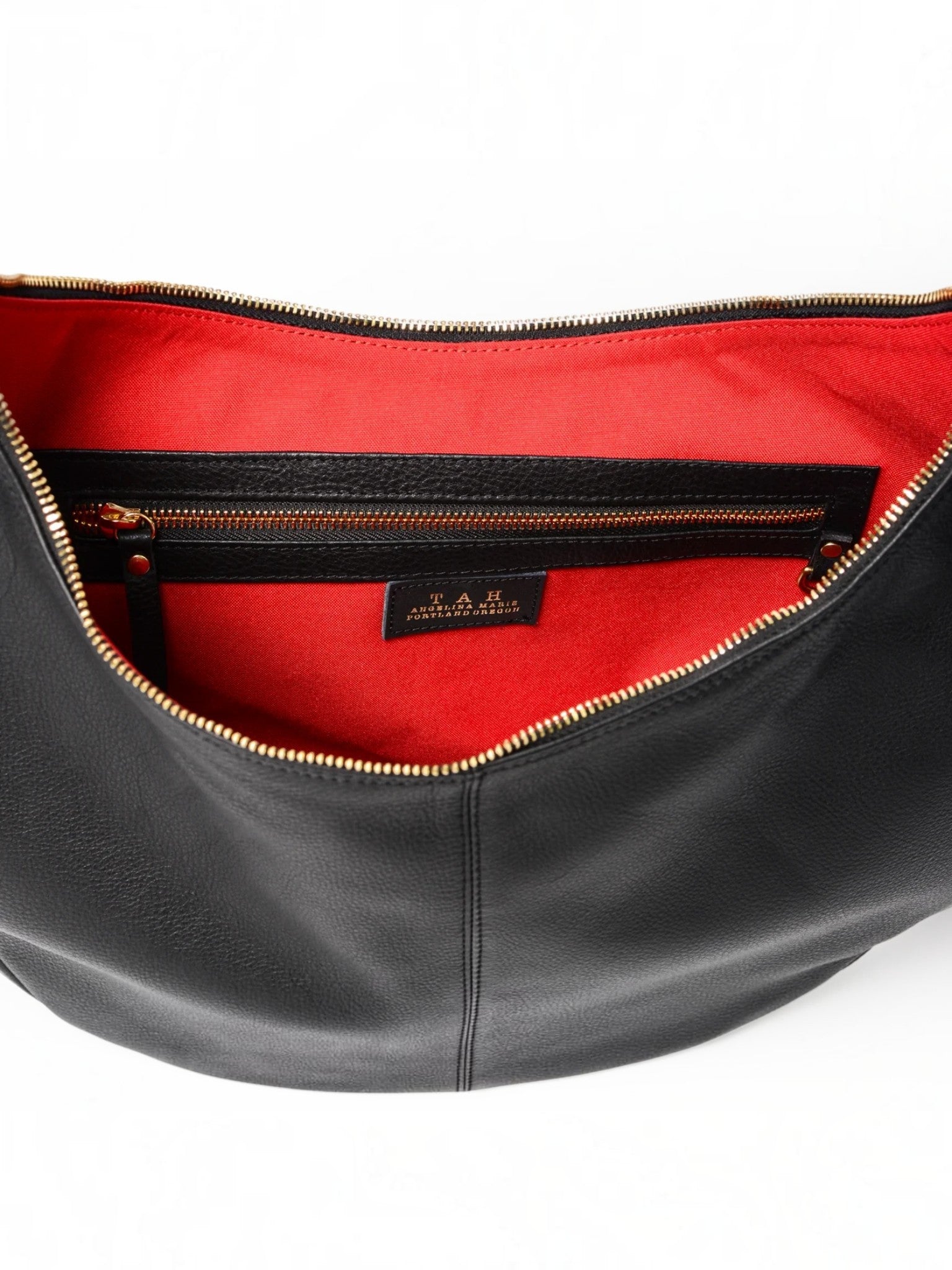 Queen Anna House of Fashion TAH Bags leather sling bag interior with vibrant red lining and gold zipper detail.