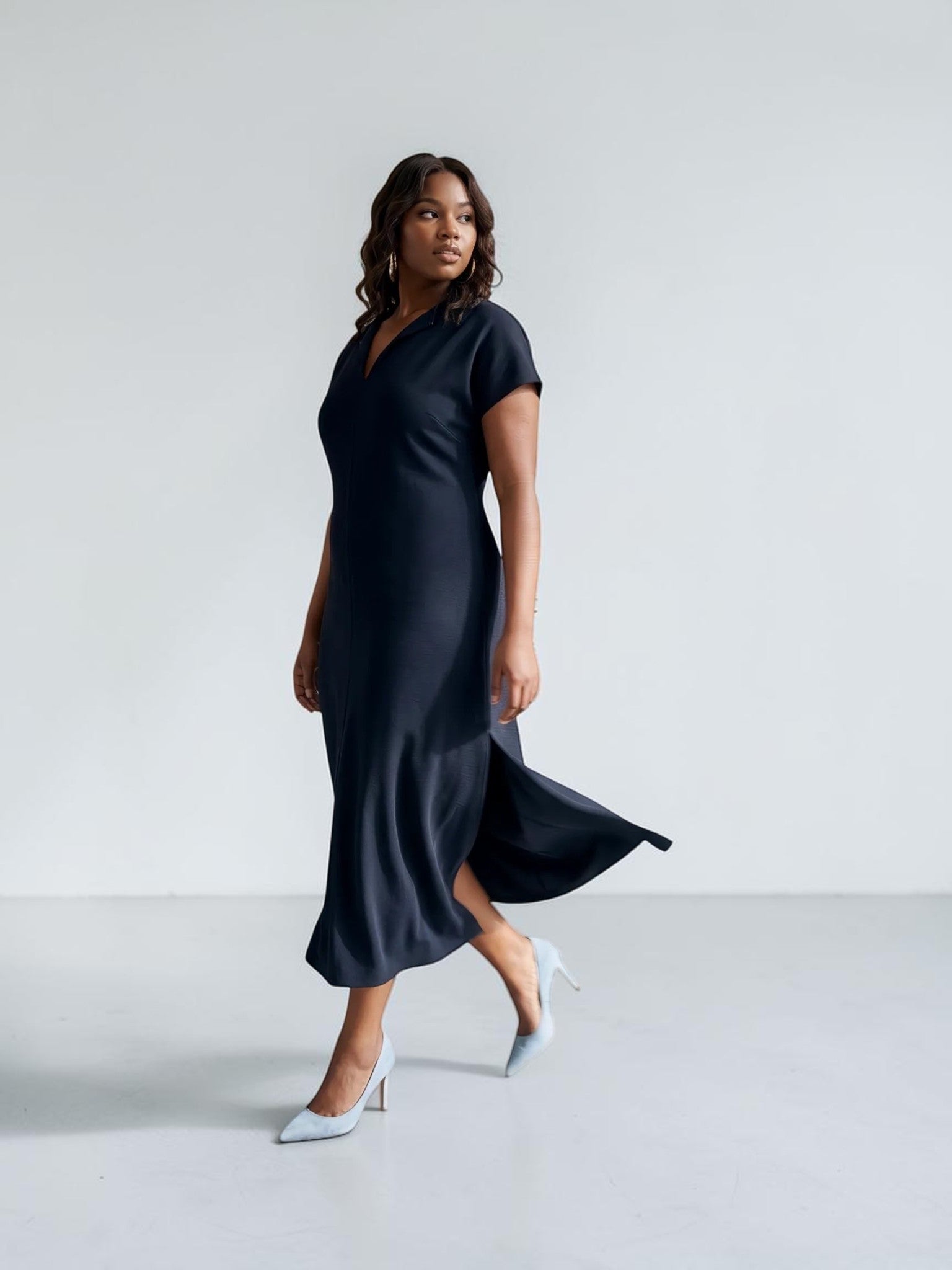 Queen Anna House of Fashion model wearing a navy blue Universal Standard Divine Jersey shift dress with side slits.