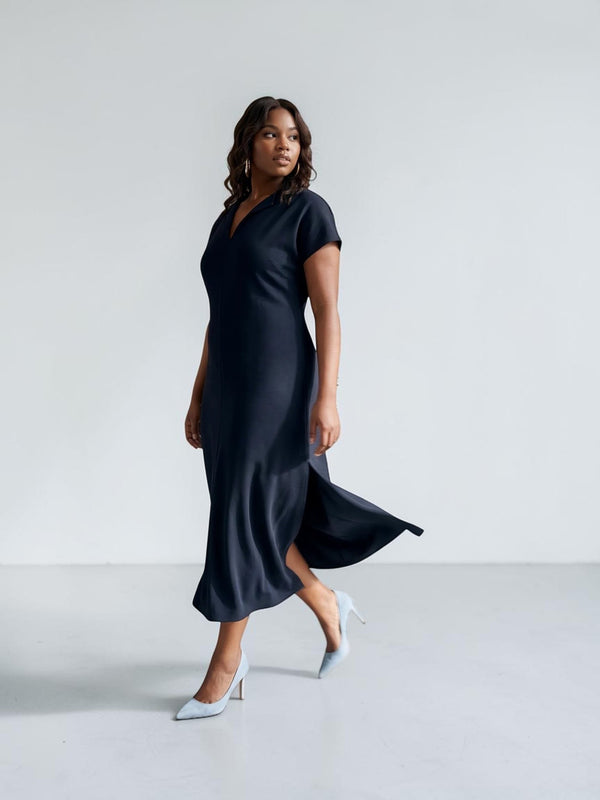 Queen Anna House of Fashion model wearing a navy blue Universal Standard Divine Jersey shift dress with side slits.