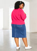Queen Anna House of Fashion model wearing a pink Universal Standard Better Than Wool cardigan and denim skirt
