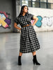Queen Anna House of Fashion model wearing a black and white plaid stretch poplin midi shirtdress with a brown belt.
