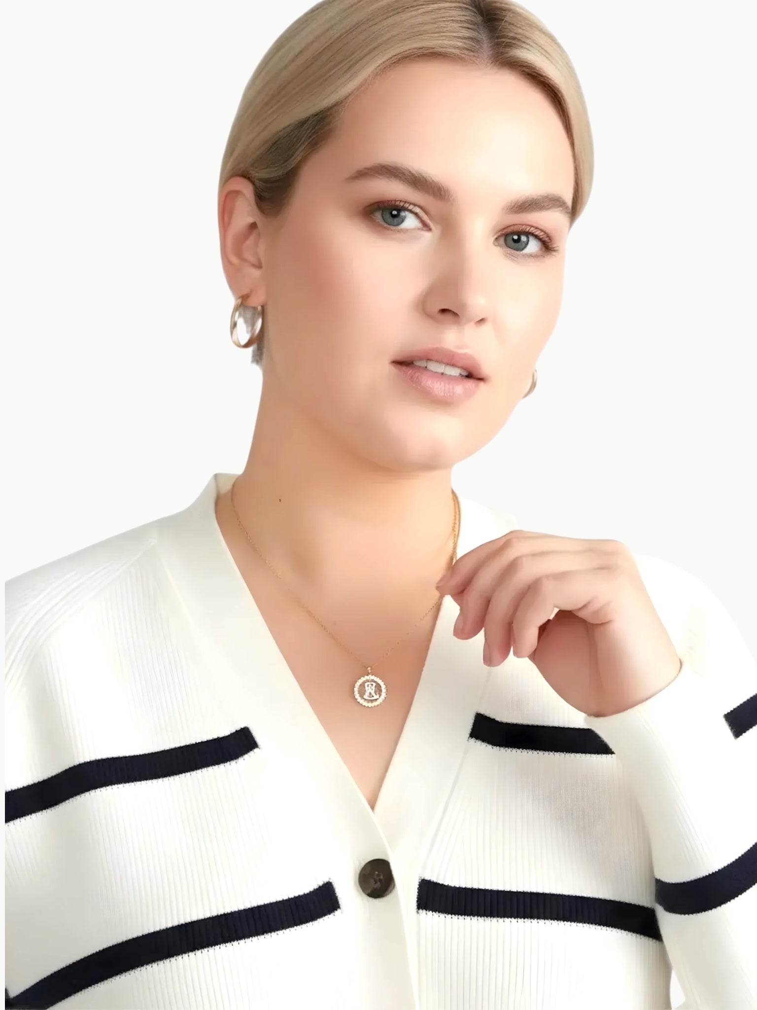 Queen Anna House of Fashion model wearing a white and black striped Better Than Wool cardigan with a V-neckline.
