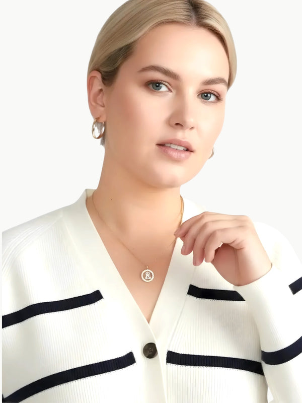 Queen Anna House of Fashion model wearing a white and black striped Better Than Wool cardigan with a V-neckline.