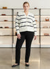 Queen Anna House of Fashion model wearing a white and black striped Better Than Wool cardigan with black trousers.