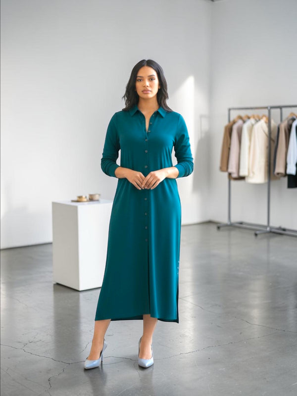 Queen Anna House of Fashion model wearing a teal Universal Standard liquid jersey long-sleeve button-down shirt dress.