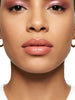 Model wearing Queen Anna House of Fashion Bossy Cosmetics Unapologetic pink nude lip gloss with a high-gloss finish.
