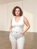 Queen Anna House of Fashion model wearing a white Universal Standard Double V tank top with light wash jeans.