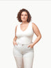 Queen Anna House of Fashion model wearing a white Universal Standard Double V tank top with light wash jeans.